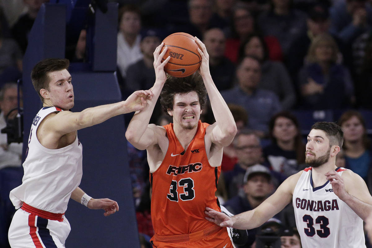 Pacific center James Hampshire, center, grabs a rebound between Gonzaga forwards Filip Petrusev ...