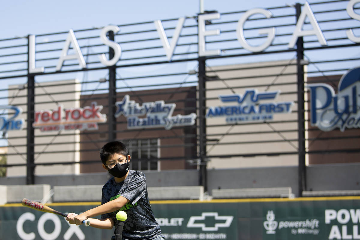 After getting the first dose of the Pfizer COVID-19 vaccination, Joe Kimoto, 12, learns batting ...