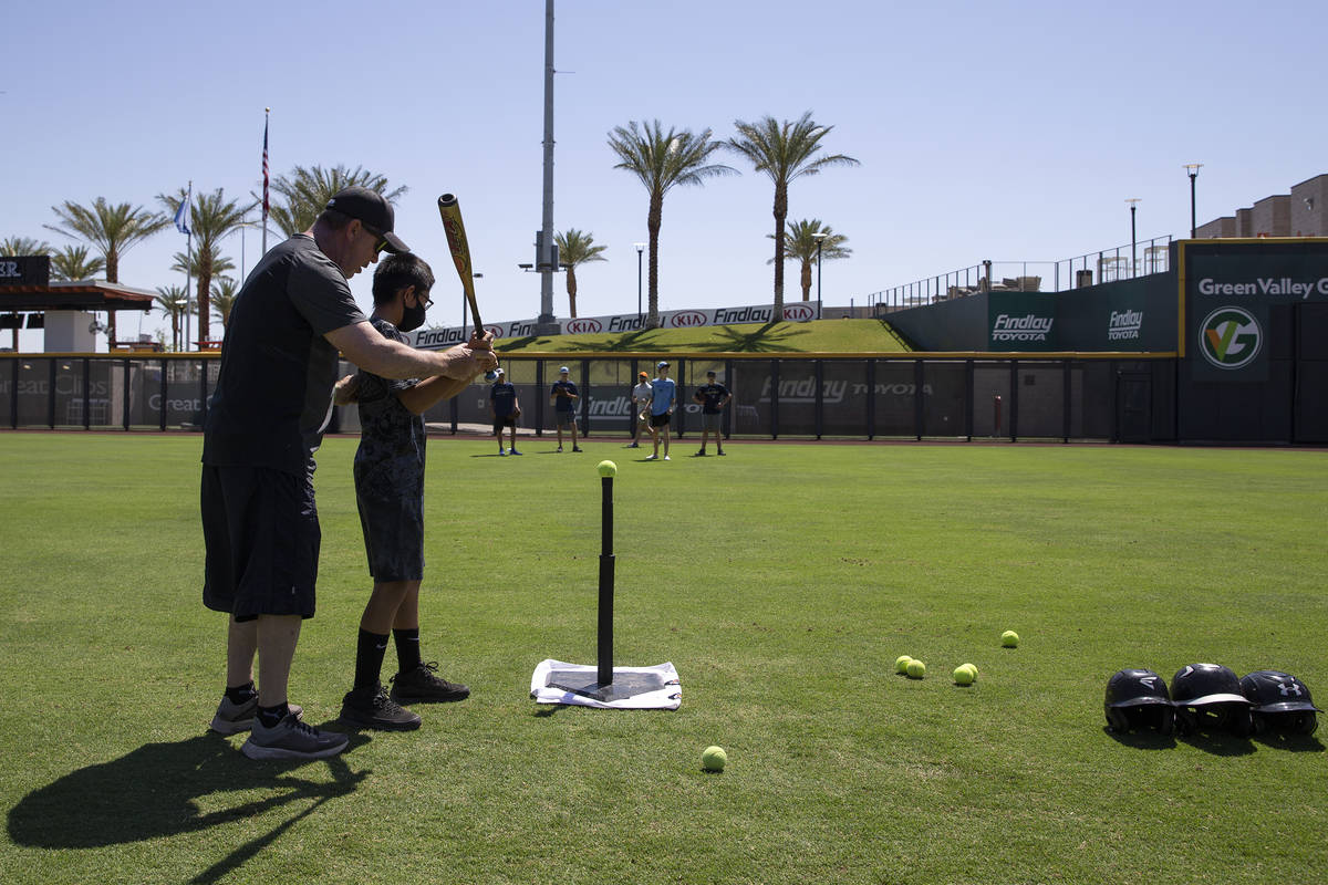 Mike Shannon, county liason for Clark County Commissioner Justin Jones, teaches batting skills ...