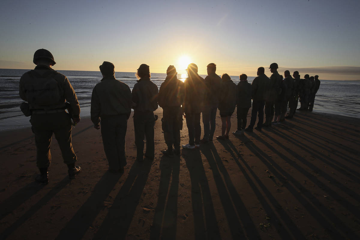 World War II reenactors pay tribute to soldiers at dawn at the shore of Omaha Beach in Saint-La ...