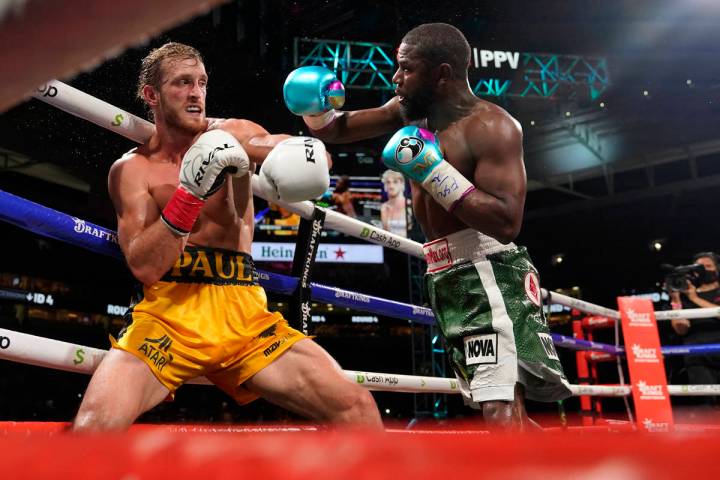 Floyd Mayweather, right, throws a punch at Logan Paul, left, during an exhibition boxing match ...