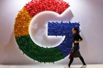 In this Monday, Nov. 5, 2018 file photo, a woman walks past the logo for Google at the China In ...