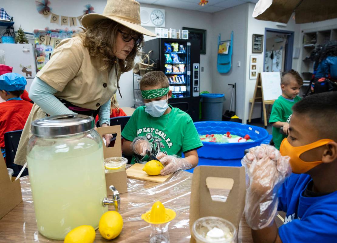 Kay Carl Elementary School Principal, Brenda Swann, watches Shawn Davignon, 11, center, slicing ...