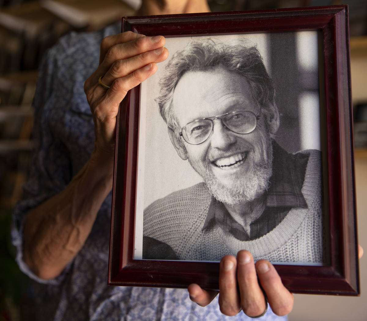 Judy Polumbaum, daughter of news photographer Ted Polumbaum, holds a photo of her father at her ...