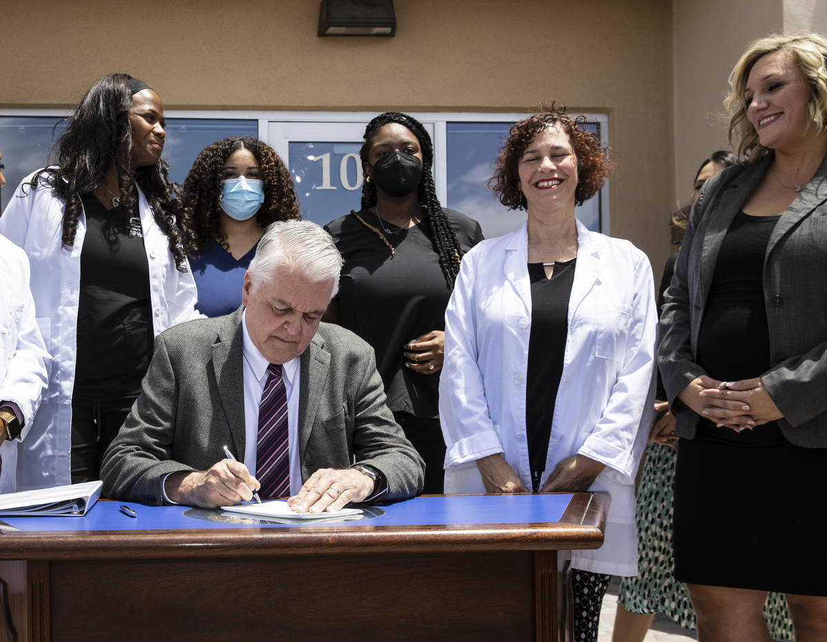 Gov. Steve Sisolak signs Senate Bill # 420, the bill that will provide a public health care opt ...