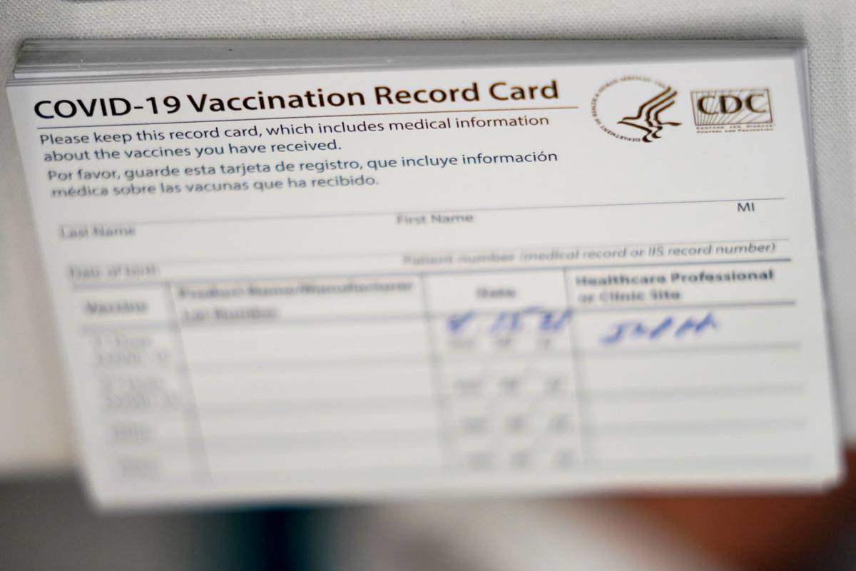 A stack of COVID-19 vaccination record cards are shown at the Christine E. Lynn Rehabilitation ...