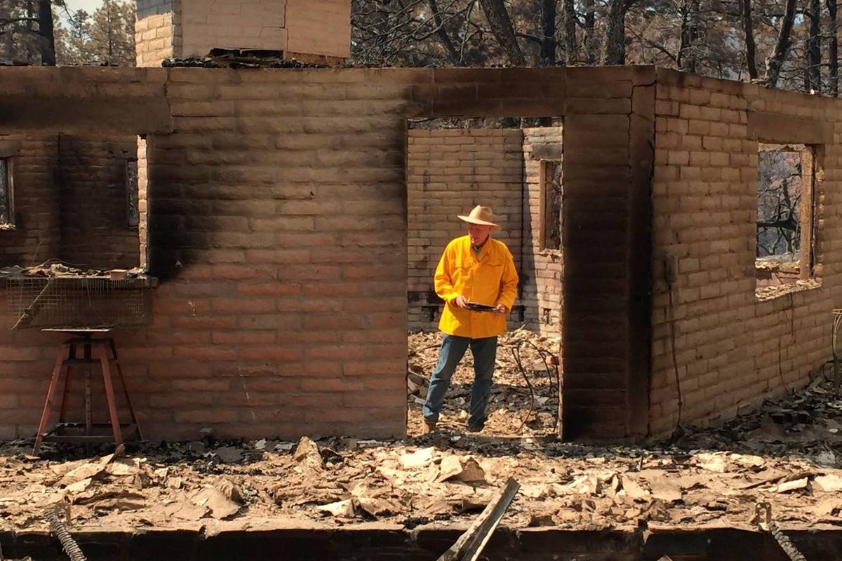 Arizona House Speaker Rusty Bowers walks through the remains of his family's weekend home on Tu ...