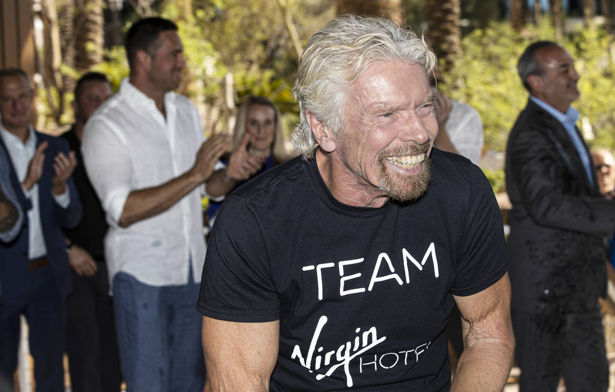 Sir Richard Branson, right, founder of Virgin Group, shares a laugh with attendees after poppin ...
