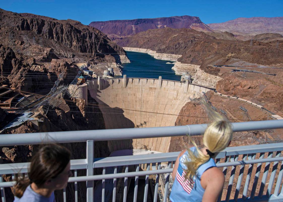 Tourists look out at Lake Mead and the Hoover Dam while walking on the Mike O'CallaghanÐPa ...