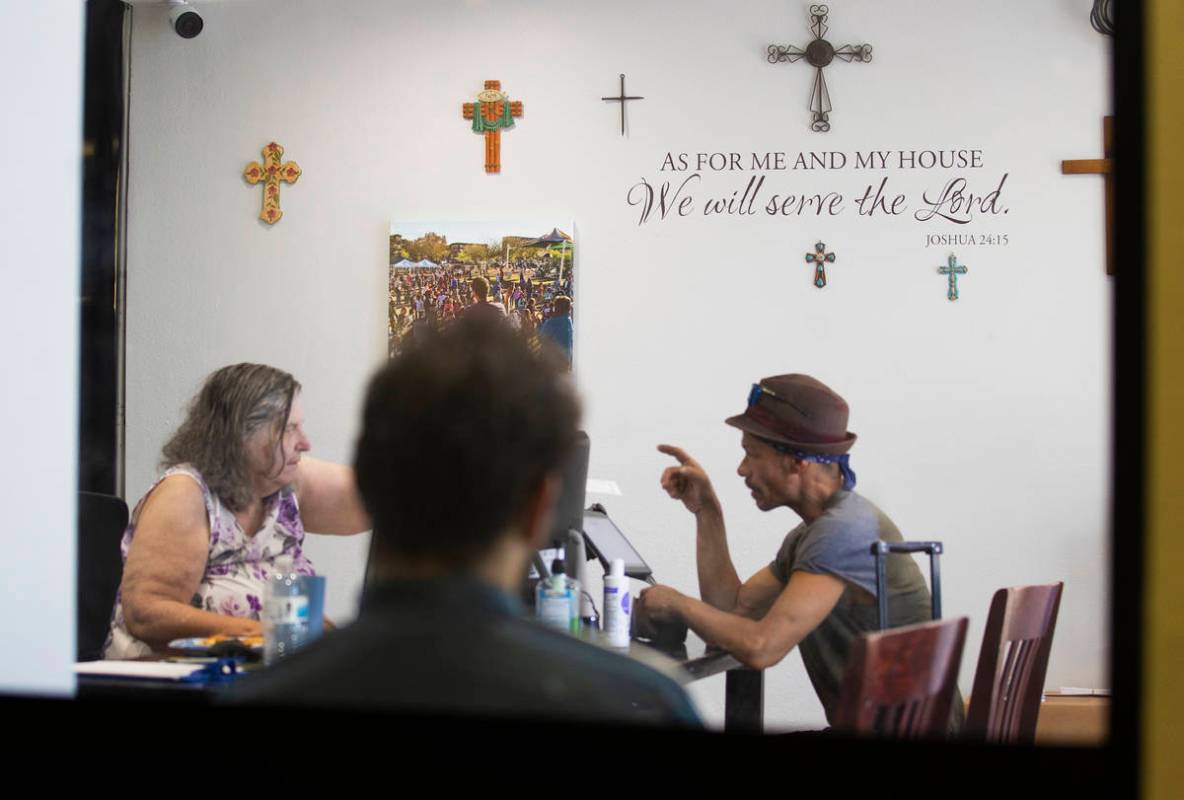 Volunteer Dona Losse, left, processes clients before they enter the food bank at City Impact Ce ...