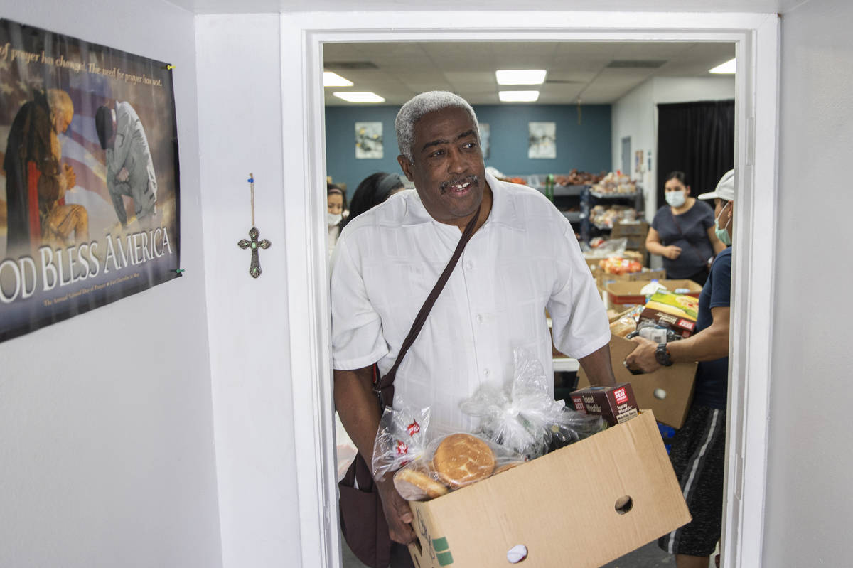Jimmy Stewart walks out of the food bank with a box of groceries at City Impact Center on Tuesd ...