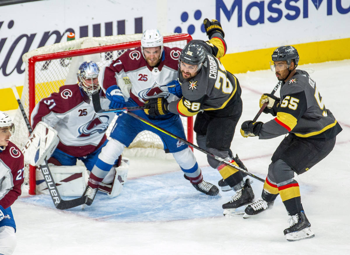 Golden Knights left wing William Carrier (28) and Colorado Avalanche defenseman Devon Toews (7) ...