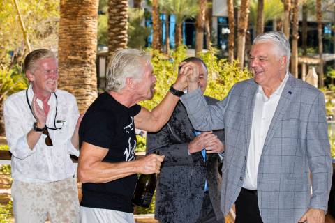Sir Richard Branson, second from left, founder of Virgin Group, high fives Gov. Steve Sisolak a ...