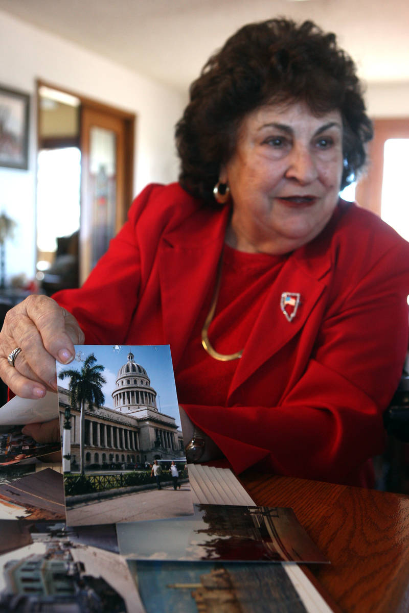 Liliam Lujan Hickey holds a photograph of the Capital Building in Havana, Cuba, while talking i ...