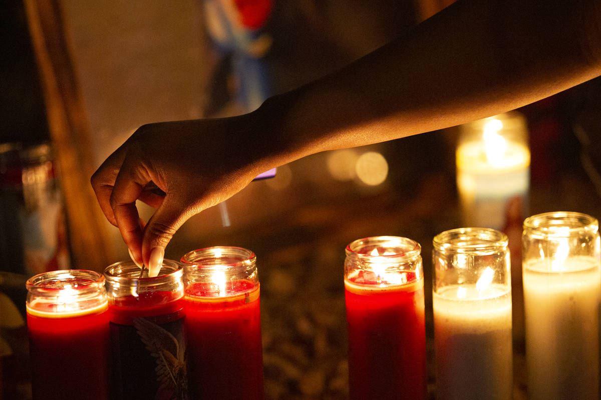 Attendees keep the candles lit at a vigil for Walter Anderson near the intersection where he wa ...
