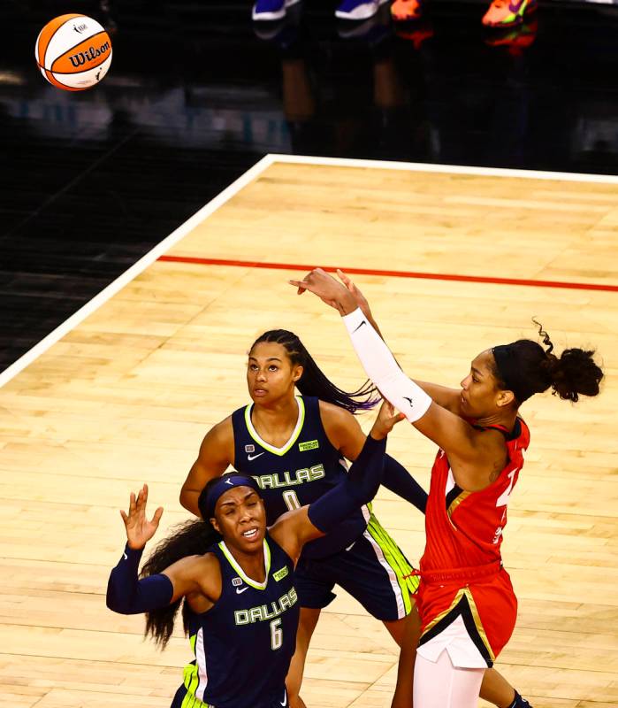 Las Vegas Aces' A'ja Wilson (22) shoots over Dallas Wings' Kayla Thornton (6) and Satou Sabally ...