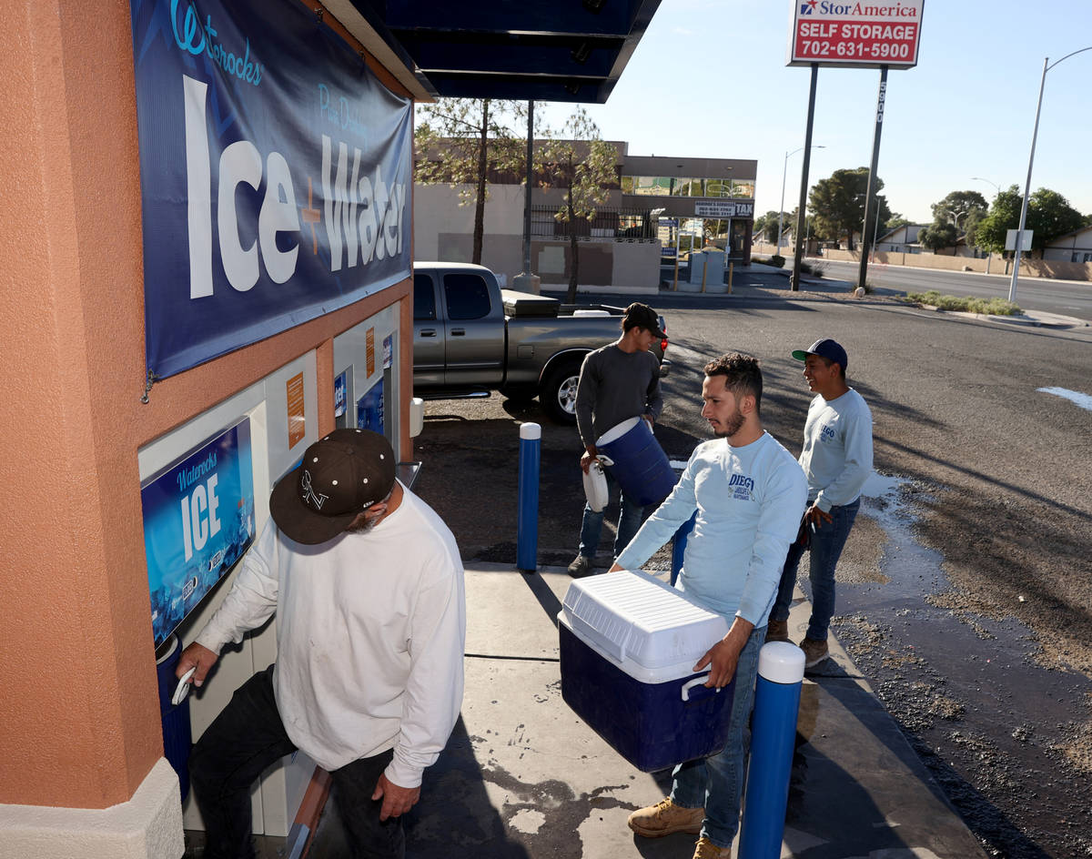 Josue Enrique, from right, Geovanni Lara and Marlon Bonilla wait in line to get ice for their w ...