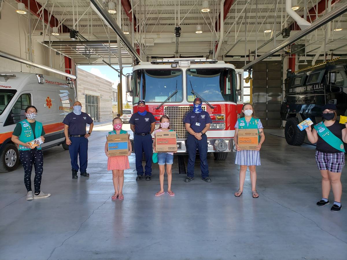 This undated photo provided by Girl Scouts of New Mexico Trails shows scouts donating cookies t ...