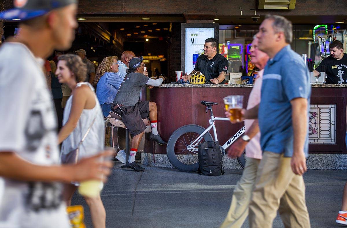 Visitors stop for a drink at the Cowgirl Up Cantina as others wander along the shops and casino ...