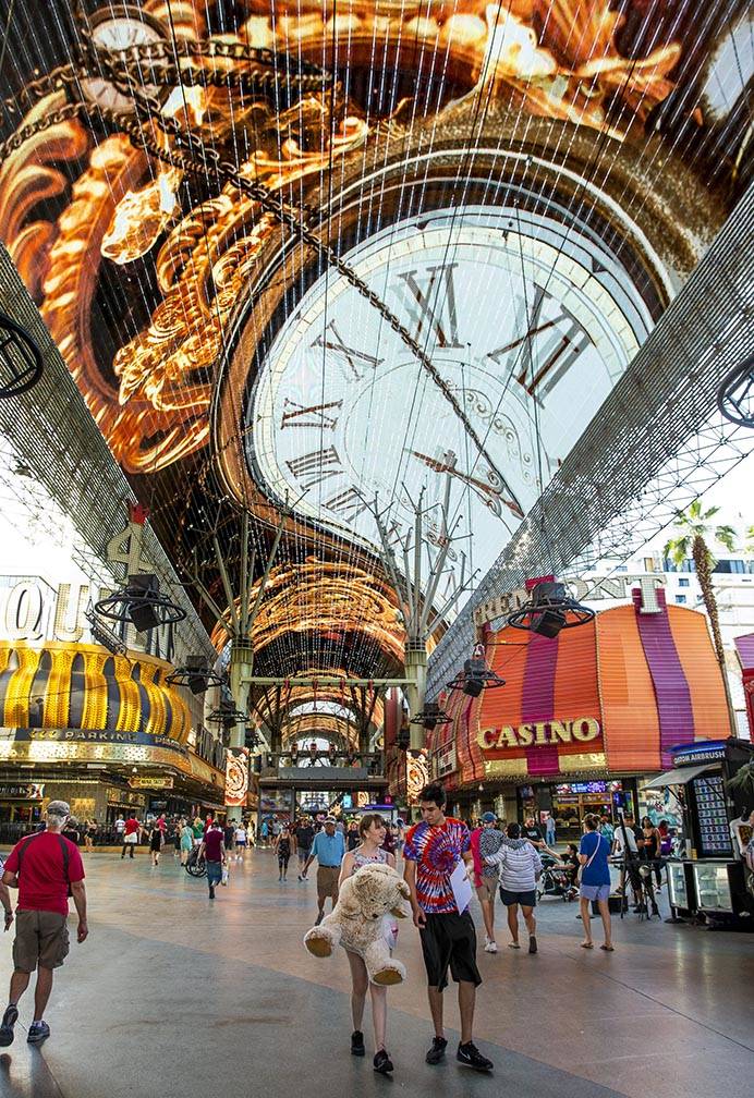 Visitors wander along the shops and casinos as the Viva Vision plays above at the Fremont Stree ...