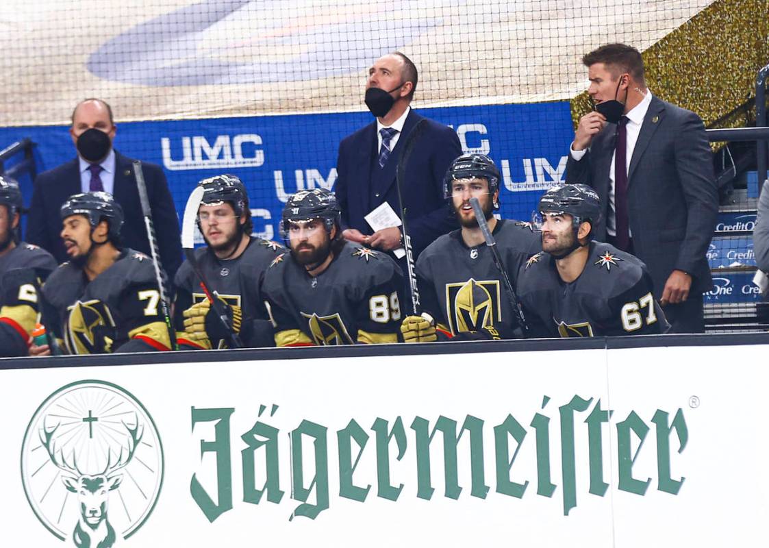 Golden Knights head coach Pete DeBoer, center, looks on from the bench during the first period ...