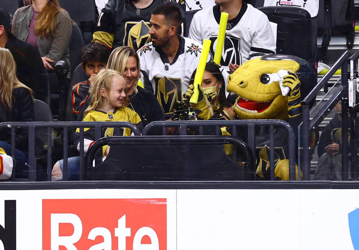 Golden Knights mascot Chance, right, hangs out with a young fan during the first period of Game ...