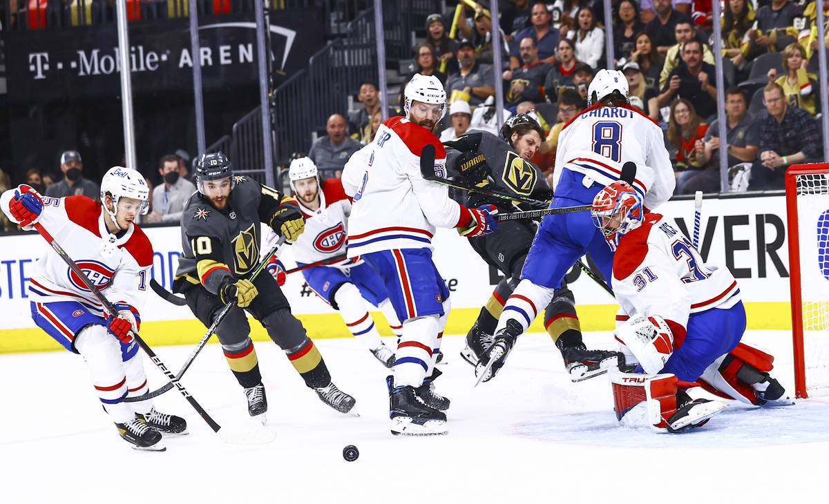 Golden Knights' Nicolas Roy (10) eyes the puck between Montreal Canadiens' Jesperi Kotkaniemi ( ...