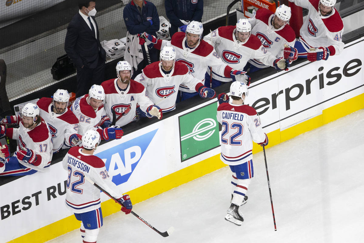 Canadiens right wing Cole Caufield (22) is congratulated by his teammates after scoring a goal ...