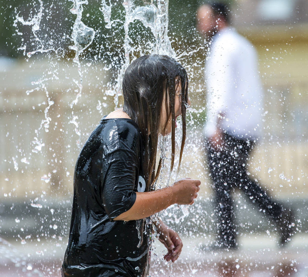 Lexie Cabrerra, 11, of Baker City, Oregon, is pounded with water on the splash pad at Bob Baski ...