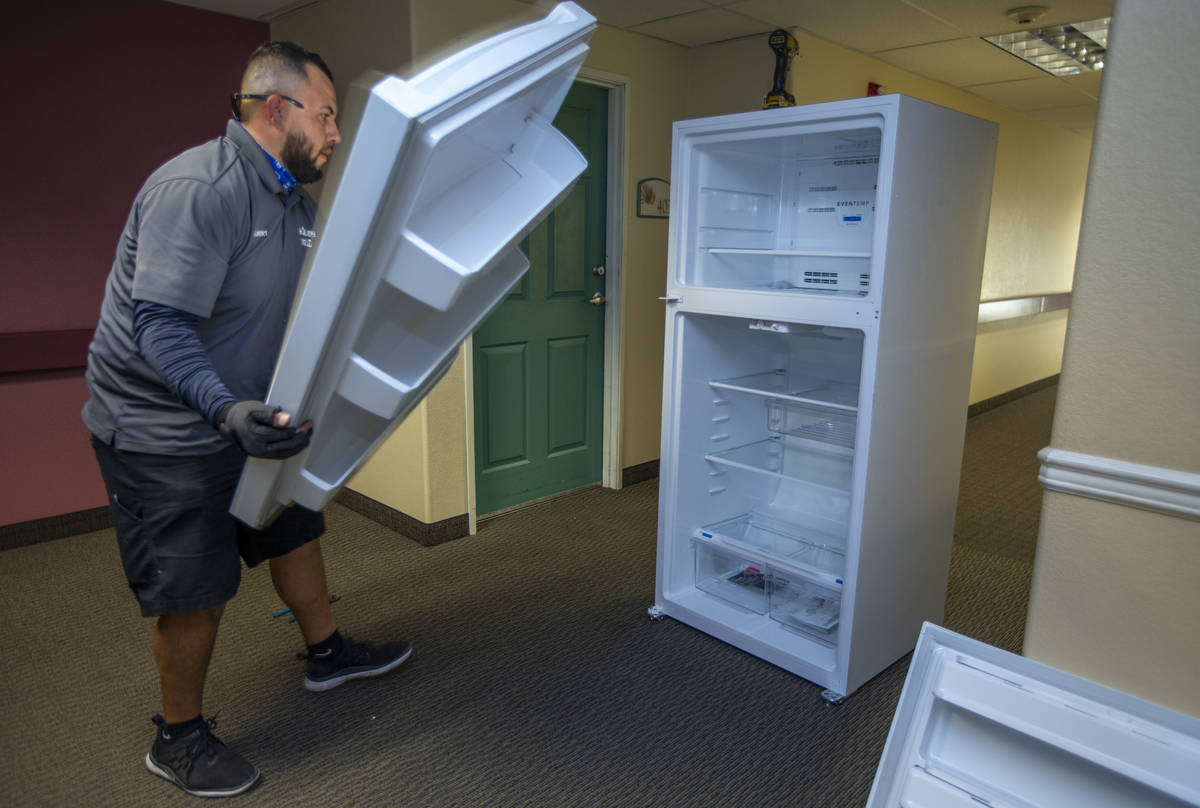 Lowe's employee Albert Vazquez reverses the doors on one of the 98 fridges at Bonanza Pines Sen ...