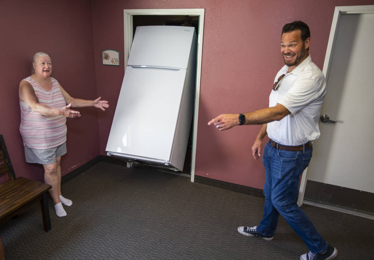Resident Dianne Holmes, left, jokes with Lowe's employee Brett Samperi as he helps deliver one ...