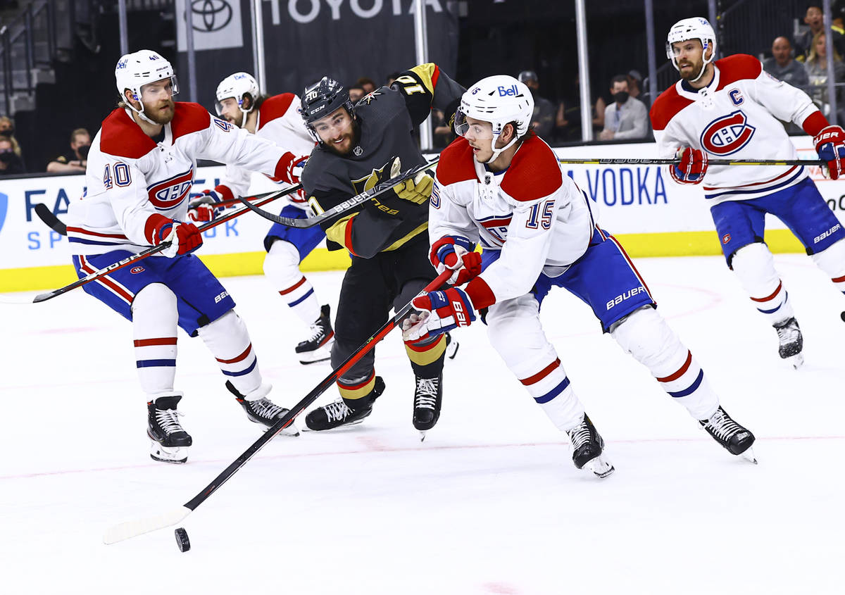 Golden Knights' Nicolas Roy (10) battles for the puck between Montreal Canadiens' Joel Armia (4 ...