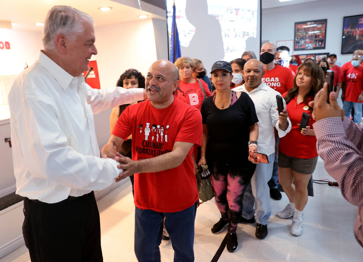 Culinary Workers Union Local 226 member Mario Sandoval, second from right, greets Gov. Steve Si ...