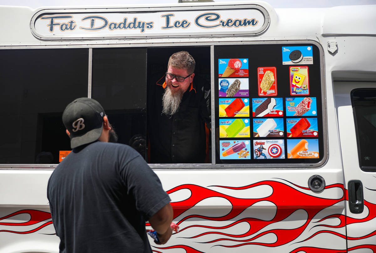 Al Davis, owner of Fat Daddys Ice Cream truck, sells ice cream to Caliber Collision employees o ...