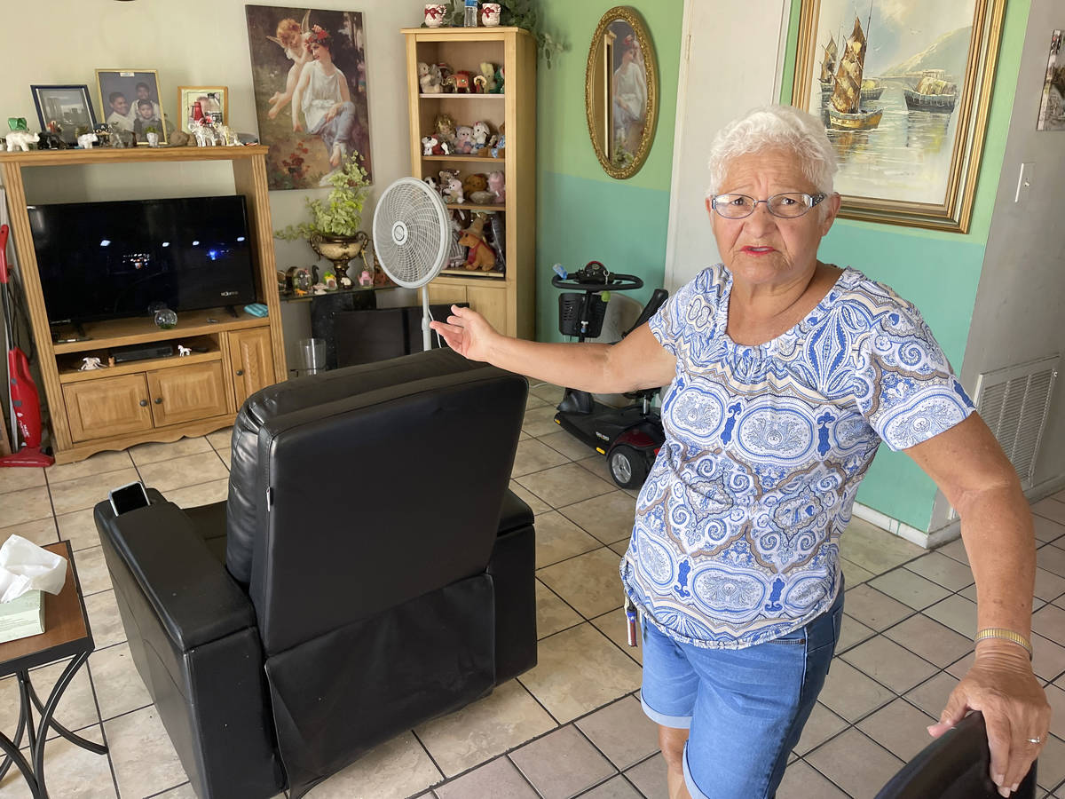 Carmen Millan, 82, shows a fan she uses with open windows and door to keep cool at her apartmen ...