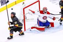 The puck flies over Golden Knights' Mark Stone (61) as Montreal Canadiens goaltender Carey Pric ...