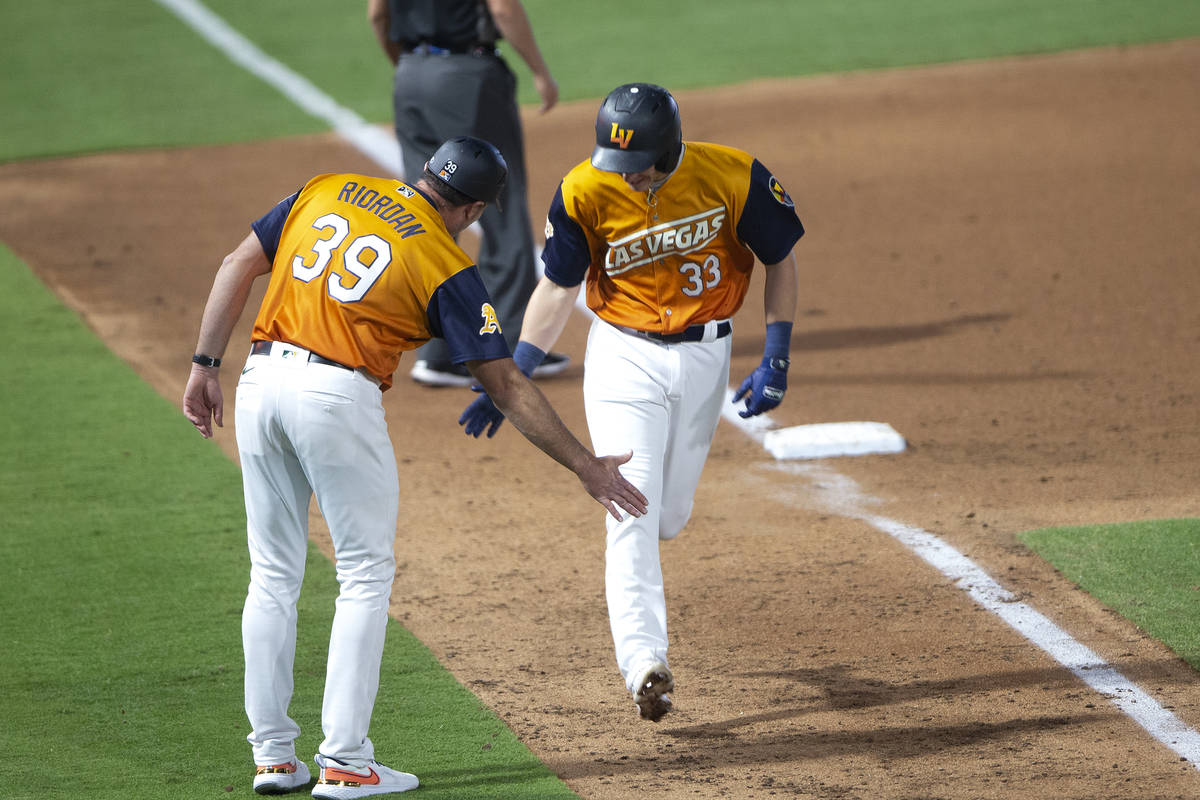 Aviators infielder Frank Schwindel (33) high fives manager Fran Riordan (39) as he rounds the b ...