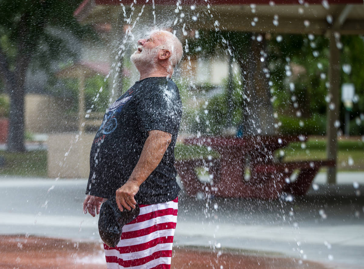 Robert Burnzott cools off in the fountains about the splash pad at Bob Baskin Park on Tuesday, ...