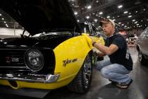Dean Swan, of Idaho, polishes his 1969 Chevrolet Camaro custom coupe, showcased in the Barrett- ...