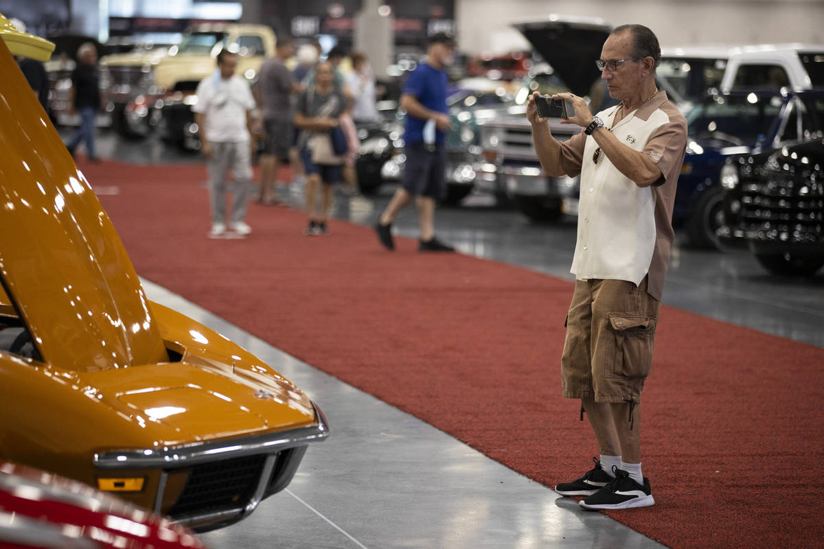 Erwin of Las Vegas, who declined to give a last name, takes photos in the showroom floor while ...