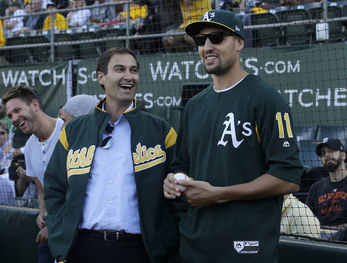 Oakland Athletics president Dave Kaval, left, laughs with Golden State Warriors basketball play ...