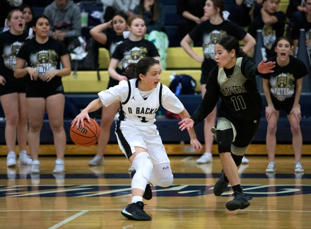Desert Oasis guard Autiyjah Pricebrooks (3) dribbles around Spring Valley's center Kenna Scott ...