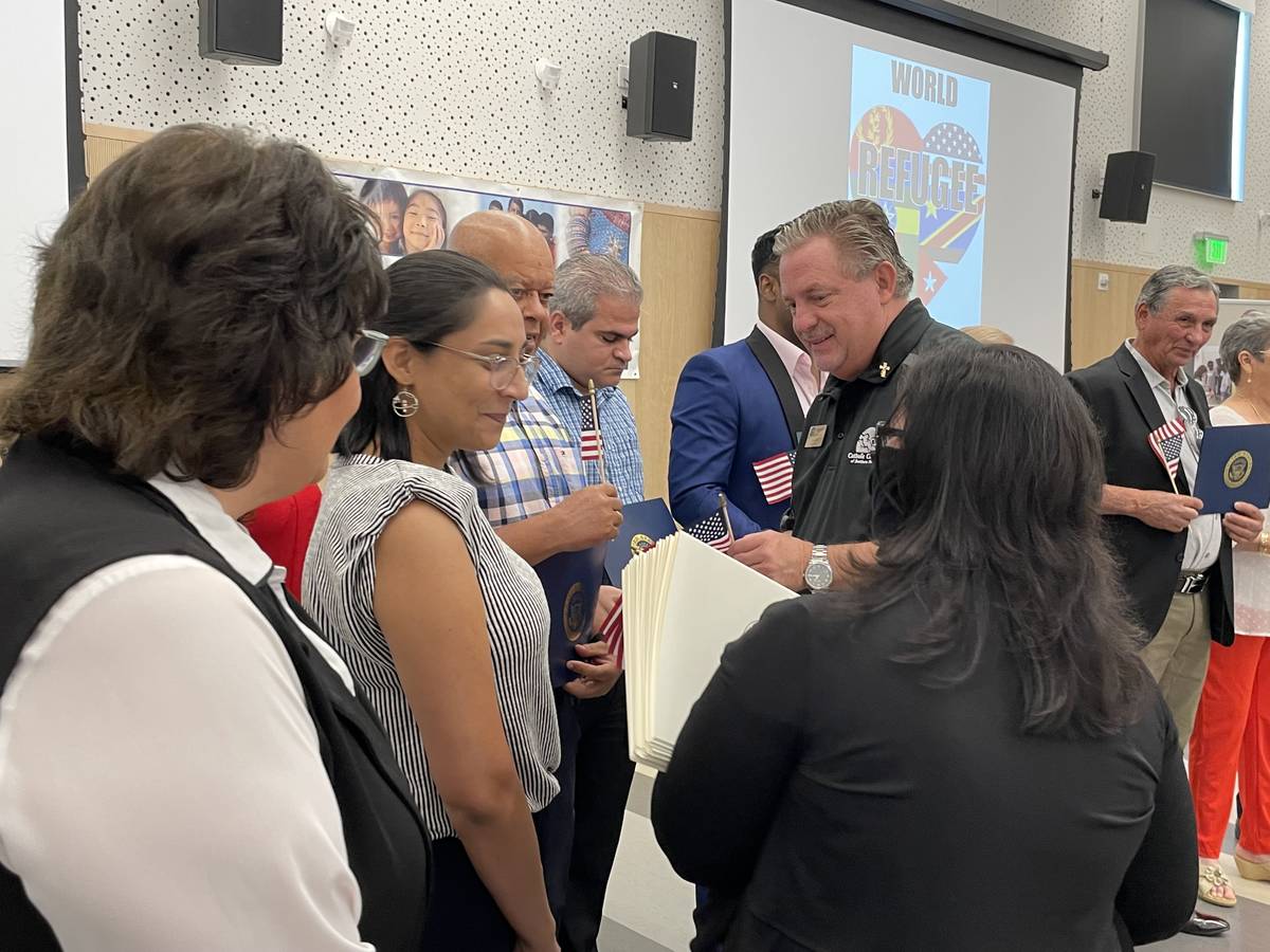 Deacon Tom Roberts, CEO of Catholic Charities of Southern Nevada, passes out American flags to ...