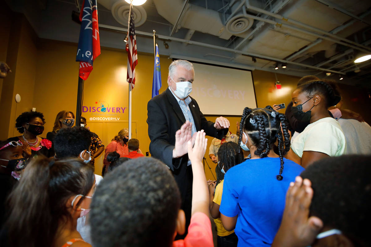 Nevada. Gov. Steve Sisolak high-fives children during a Juneteenth celebration at the Discovery ...