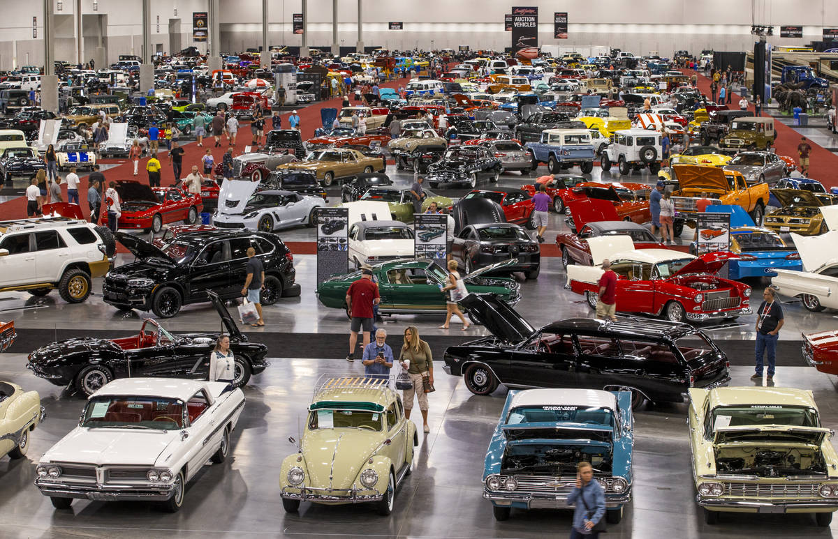 Attendees walk about some of the numerous cars already sold and still up for bid during the Bar ...