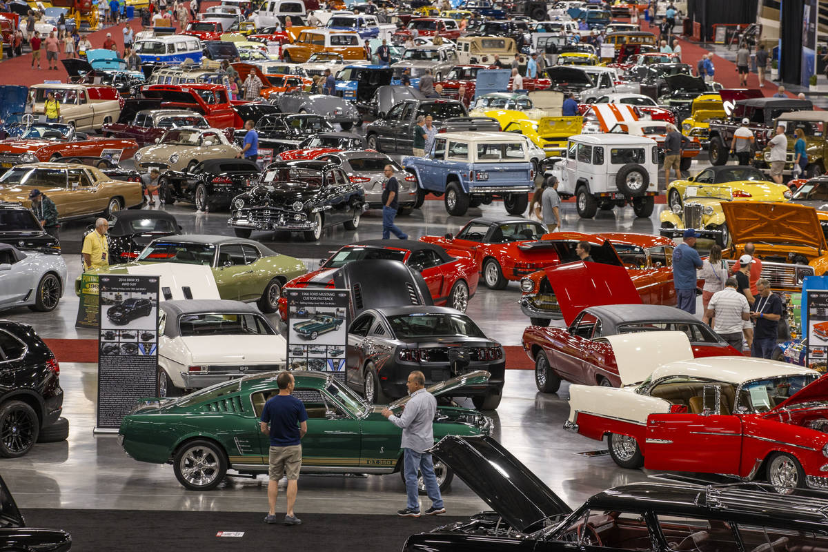 Attendees walk about some of the numerous cars already sold and still up for bid during the Bar ...