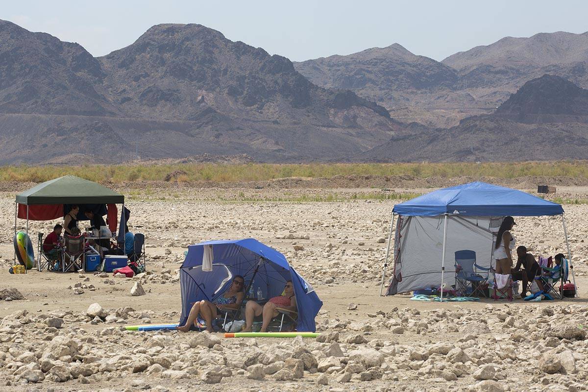 Beach-goers shade themselves along Boulder Beach at Lake Mead on Saturday, June 19, 2021, near ...