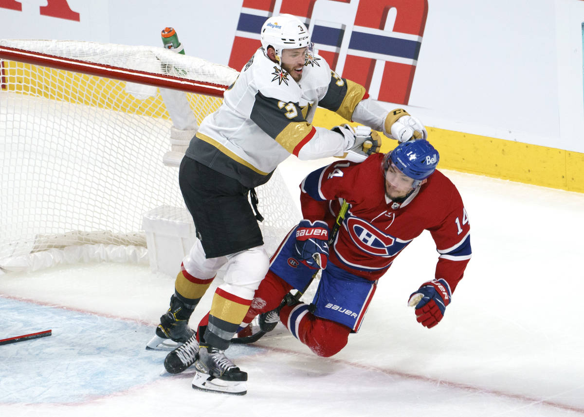 Montreal Canadiens' Nick Suzuki is taken out by Vegas Golden Knights' Brayden McNabb (3) during ...
