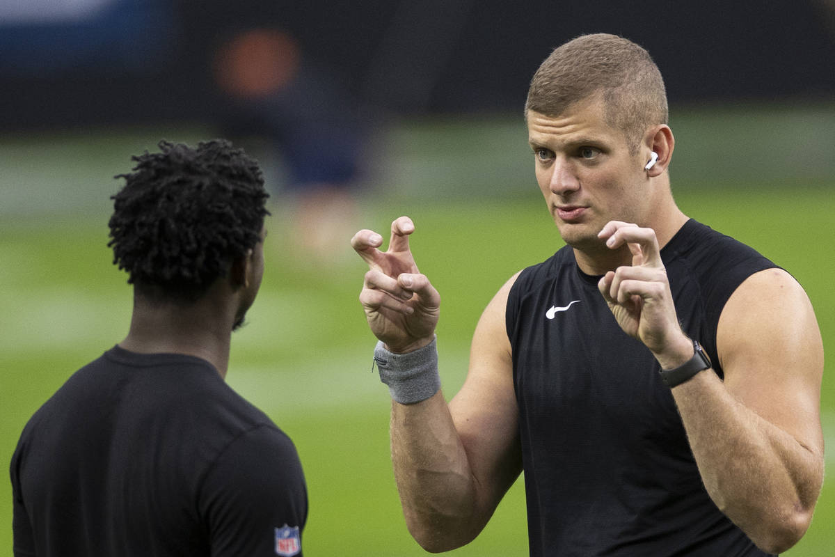 Las Vegas Raiders defensive end Carl Nassib, right, talks with Las Vegas Raiders cornerback Tra ...