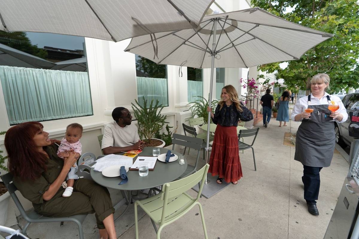 Caroline Styne, owner and wine director at The Lucques Group, standing under umbrella, welcomes ...